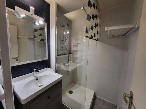 une salle de bain blanche avec un lavabo et une douche dans l'établissement Résidence Cheval Noir - Le Cheval Noir 9 - 2 pièces joliment rénové avec terrasse MAE-5584, à Valmorel