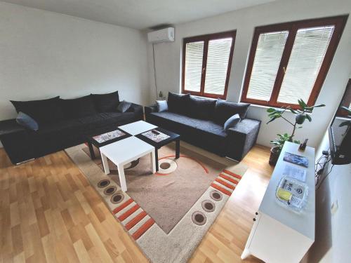 una sala de estar con un sofá y una mesa en Apartman Komfor, en Banja Luka