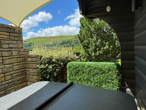 a view from the outside of a house with a bench at LARCHES LODGE Norwegian log cabin, wood stove & spa in Church Stretton