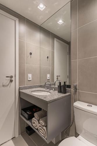 a bathroom with a sink and a toilet and a mirror at Studio aconchegante I Perdizes I Nubank Parque in São Paulo