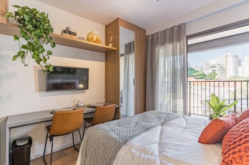 a bedroom with a bed and a desk and a tv at Studio aconchegante I Perdizes I Nubank Parque in São Paulo