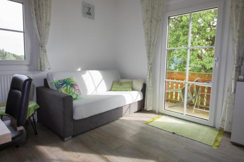a living room with a couch and a window at Ernas Ferienhaus in Aschbach bei Fürstenfeld