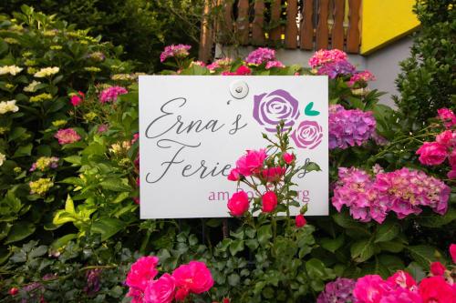 a sign in a flower garden with pink flowers at Ernas Ferienhaus in Aschbach bei Fürstenfeld