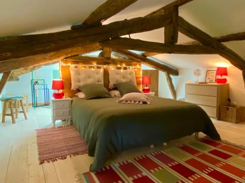 - une chambre mansardée avec un lit vert dans l'établissement Ranch du Roc, à Monteils