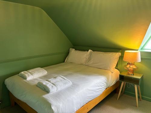 a green room with a bed with two pillows at ROOMS AT THE QUAYSIDE - stylish en-suite rooms on Poole Quay all fully refurbed in Poole