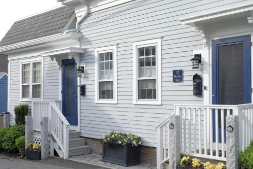 a white house with a blue door and stairs at NEW AC 1 Bedroom w Private Deck & Patio in Provincetown