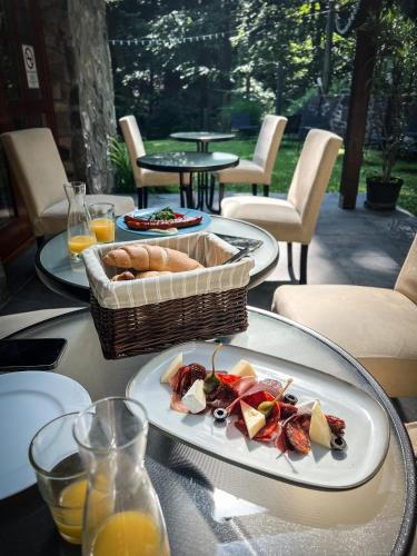 a table with two plates of food and a basket of bread at Templomvölgy Butik Hotel Mátrakeresztes in Matrakeresztes