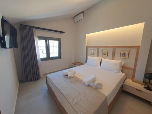 a bedroom with a large white bed with towels on it at Sealon Suite & Loft in Limenaria