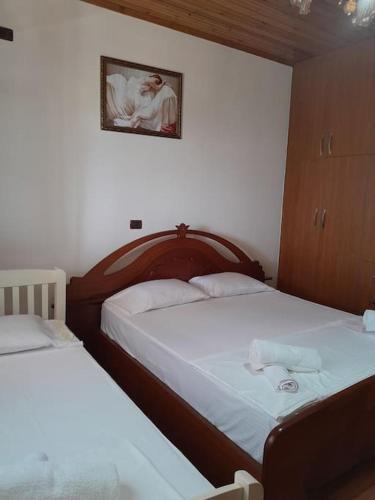 a bedroom with two beds and a picture on the wall at Sara & Mateo Guesthouse in Libohovë