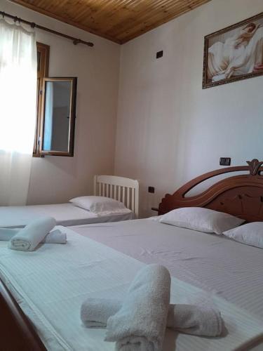 two beds in a bedroom with towels on them at Sara & Mateo Guesthouse in Libohovë