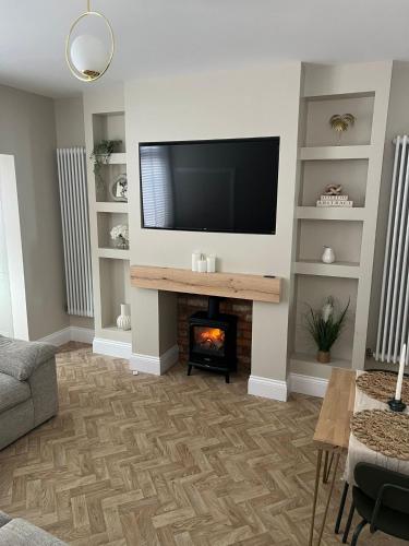 a living room with a fireplace and a flat screen tv at Gorgeous home in Leigh in Leigh