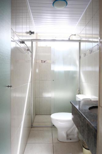 a white bathroom with a toilet and a shower at Hotel Mooca in Sao Paulo