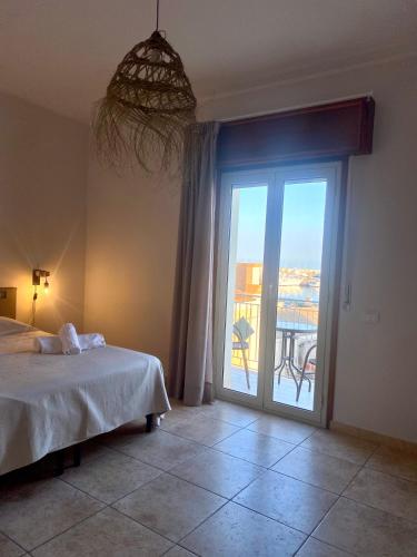 a bedroom with a bed and a large sliding glass door at VitaLenta Rooms & Apartments in Sciacca