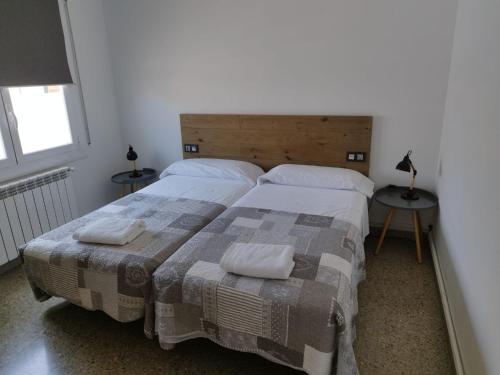 a bedroom with two beds and two tables with lamps at Apartament IXA-2 in Manresa