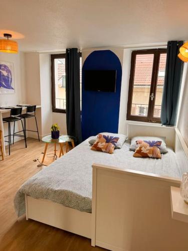 une chambre avec un grand lit avec deux oreillers dessus dans l'établissement Studio MILOS cosy hypercentre historique Thonon, à Thonon-les-Bains