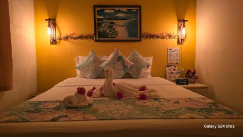 a bed with three stuffed animals sitting on it at Pousada Dona Felicidade Carneiros in Tamandaré