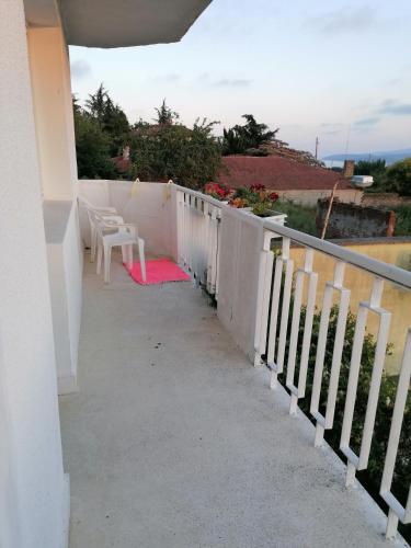 Un balcón con una alfombra roja y una barandilla blanca. en Апартаменти Захариеви 4, en Byala