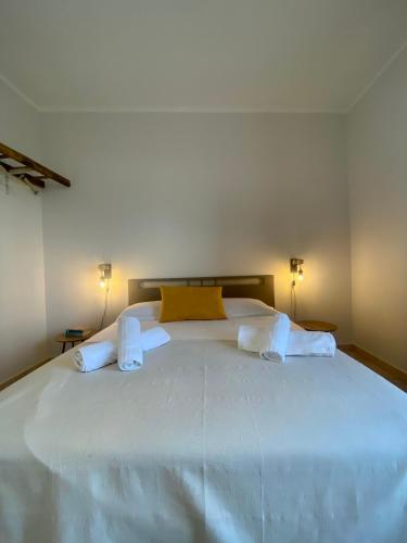 a large white bed in a room with two lamps at VitaLenta Rooms & Apartments in Sciacca