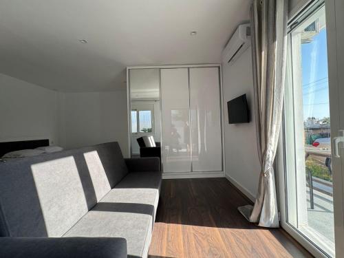 a living room with a couch and a large window at Sulozeqi Apartments in Ksamil