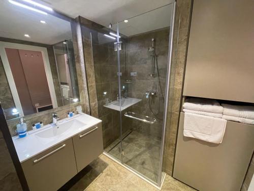 a bathroom with a glass shower and a sink at PANORAMA Apartments BATUMI in Batumi