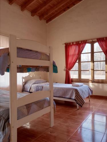 Dos literas en una habitación con ventanas. en Finca Aleden, en Salto de las Rosas