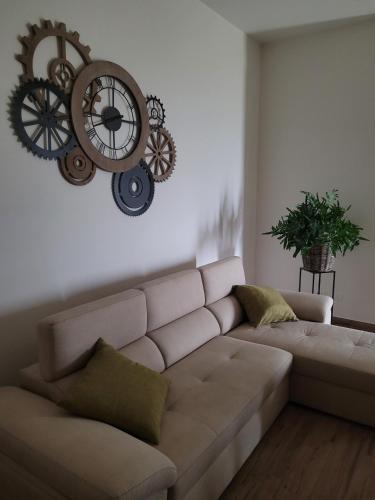 a living room with a couch and a clock on the wall at Guest house Romana Vecchia in Monticchio