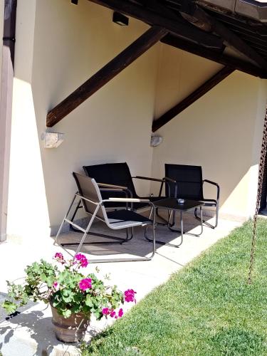 two chairs and a table on a patio with flowers at Guest house Romana Vecchia in Monticchio