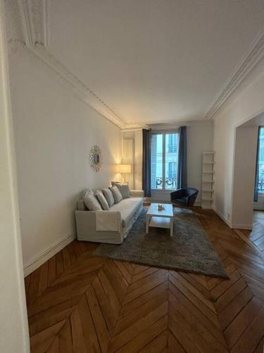 un salon avec un canapé et une table dans l'établissement 3 pièces dans le coeur du 16e, à Paris