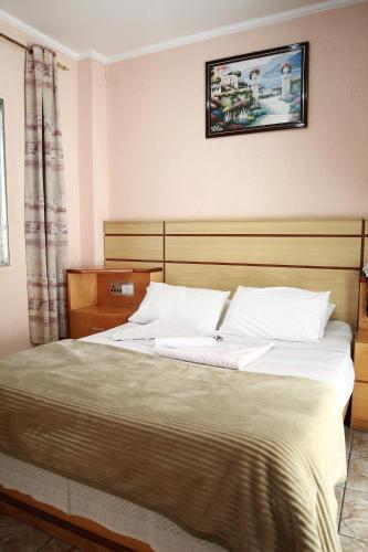 a bedroom with a large bed with a wooden headboard at Hotel Mooca in Sao Paulo