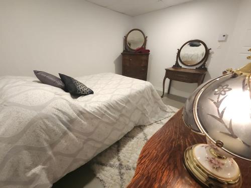 een slaapkamer met een bed en twee spiegels aan de muur bij Logis dans un Sous sol au Mont Video in Barraute