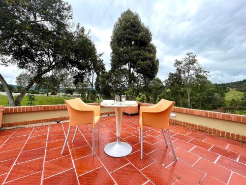 a table and two chairs on a brick patio at Lujosa Cabaña Represa del Sisga TV Wifi Cocina BBQ in Chocontá