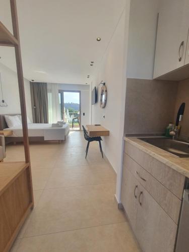 a kitchen with a sink and a room with a bed at Calma Living in Potos