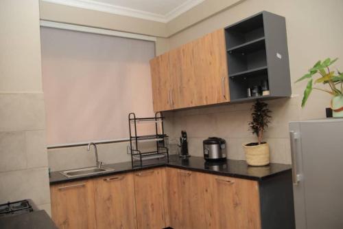 a kitchen with a sink and a counter top at Cozy Condo Najjera in Kampala
