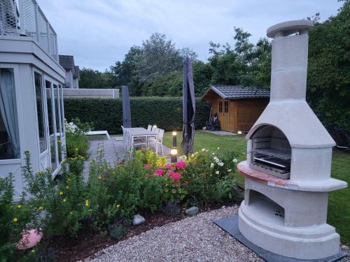 a garden with a outdoor oven in a yard at Ferienparadies Seeluft in Kamperland