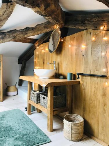 La salle de bains est pourvue d'un lavabo sur un mur en bois. dans l'établissement Ranch du Roc, à Monteils