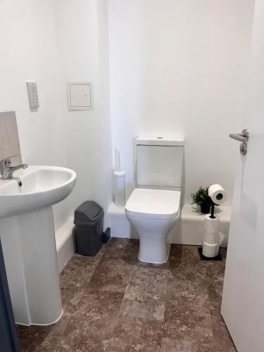 a bathroom with a white toilet and a sink at Highpoint in Bradford