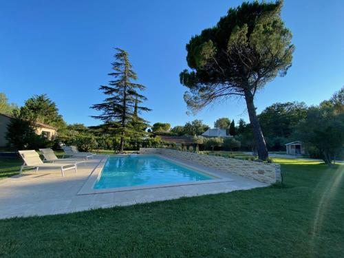 - une piscine dans une cour avec un arbre dans l'établissement Le gîte des oliviers, à Sarrians