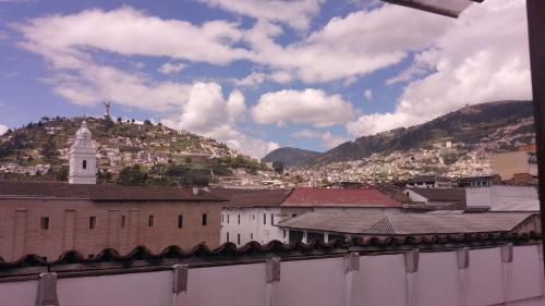 a view of a city with a hill in the background at Hotel Huasi Continental in Quito
