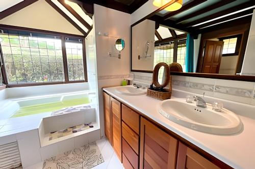 a bathroom with a sink and a tub and a mirror at Fantástica Hacienda Represa del Sisga WiFi TV BBQ in Chocontá
