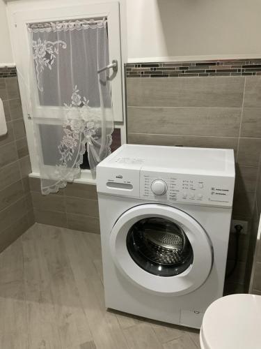 a washing machine in a bathroom with a window at Casa 700 in Civitavecchia