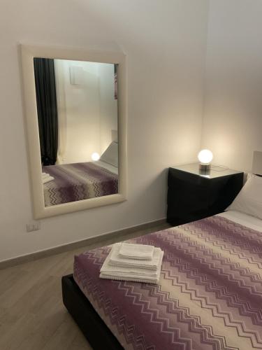a bedroom with a bed and a large mirror at Casa 700 in Civitavecchia