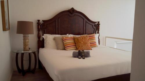 a bedroom with a bed with a wooden headboard and pillows at Casa Alhaja - Diamante in Guadalajara