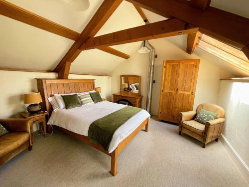 a bedroom with a large bed and a chair at Widecombe Cottage in Widecombe in the Moor
