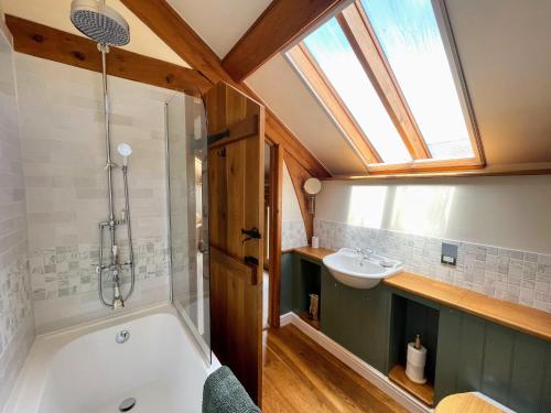 a bathroom with a tub and a sink and a window at Widecombe Cottage in Widecombe in the Moor