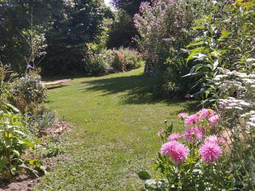 un jardin avec des fleurs roses dans l'herbe dans l'établissement jolie maison à la campagne, à Rétaud