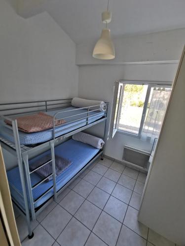 une chambre avec deux lits superposés et une fenêtre dans l'établissement Gîte Soleil, à Adissan