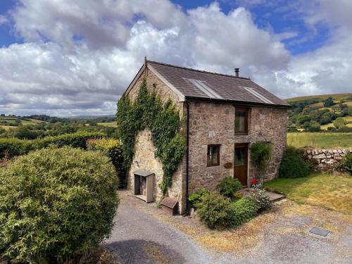 an old stone house with ivy growing on it at Widecombe Cottage in Widecombe in the Moor
