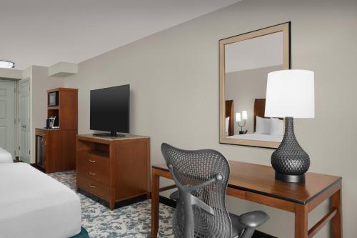 a bedroom with a desk with a chair and a mirror at Hilton Garden Inn Hoffman Estates in Hoffman Estates