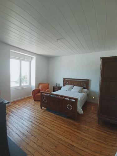 une chambre avec un lit, un canapé et une fenêtre dans l'établissement Maison chaleureuse et familiale idealement situee, à Groix