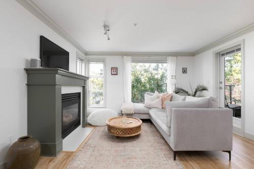 a living room with a couch and a fireplace at Boutique Beach Apartment in Vancouver